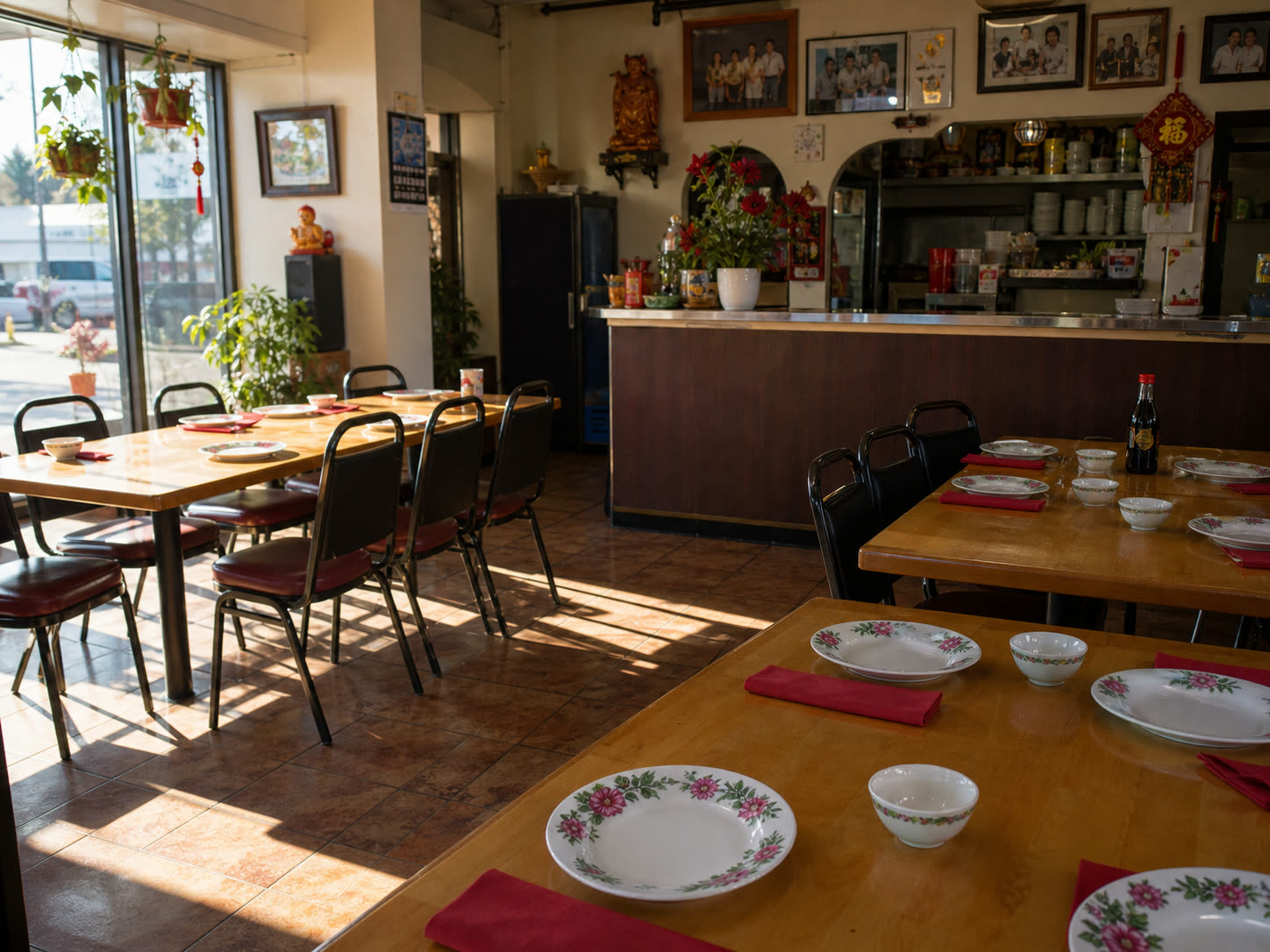 A Dong's dining room: floral china place settings, family photos on the wall, afternoon light through the front windows